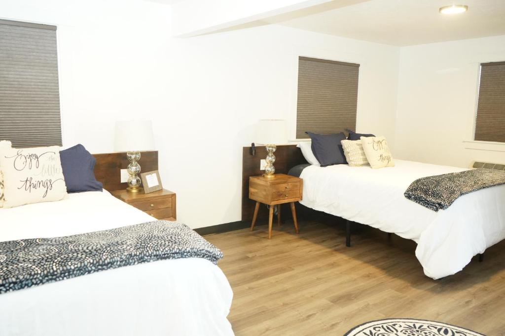 2 camas num quarto com pisos e janelas em madeira em North Idaho Inn em Coeur d'Alene