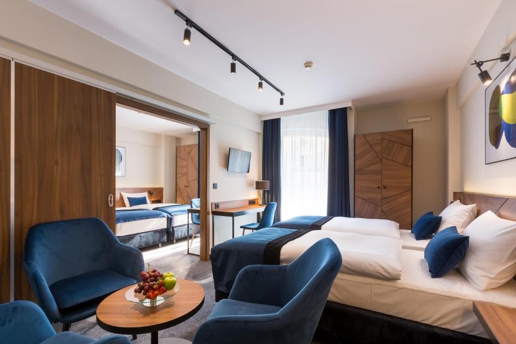 a hotel room with a bed and two chairs at Ascot Premium Hotel in Krakow