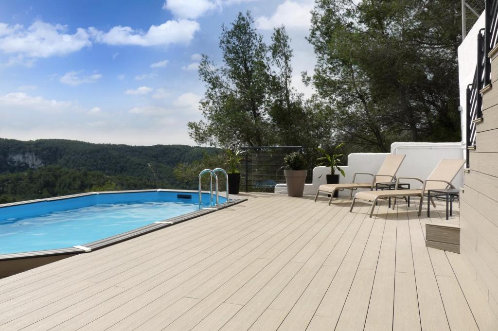 a patio with a swimming pool and a deck at TERRAVU in Sant Pere de Ribes