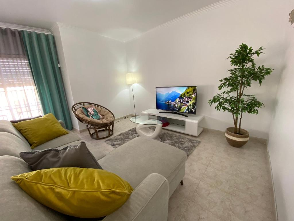 ein Wohnzimmer mit einem Sofa und einem TV in der Unterkunft Casa do Mar in Peniche