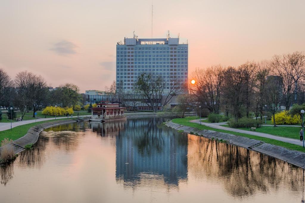 a river in a city with a building in the background at Hotel Gromada Pila in Piła