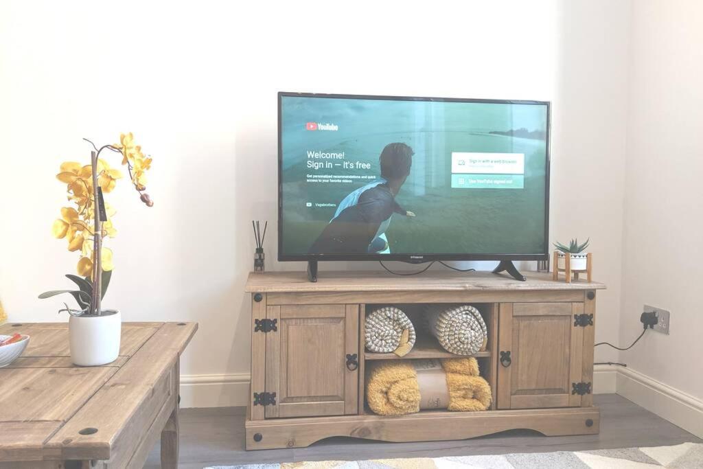 a flat screen tv sitting on top of a wooden entertainment center at NEW APARTMENT - Offline Bookings on 079-504-13594 in Bradford