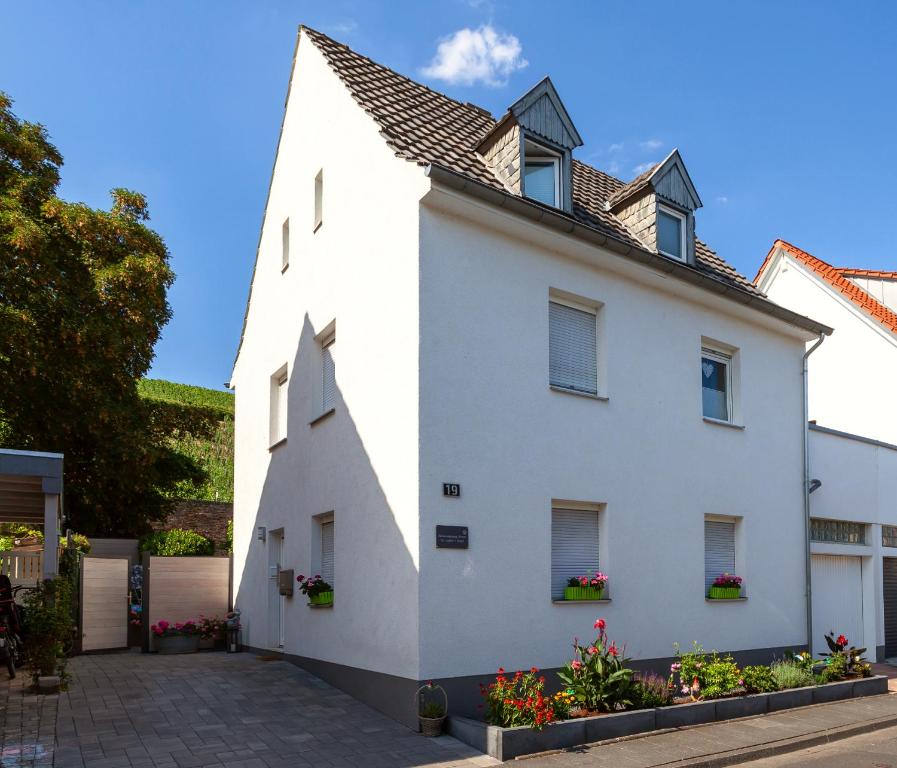 a white house with flowers in a courtyard at Ferienwohnung Emmi in Bad Neuenahr-Ahrweiler