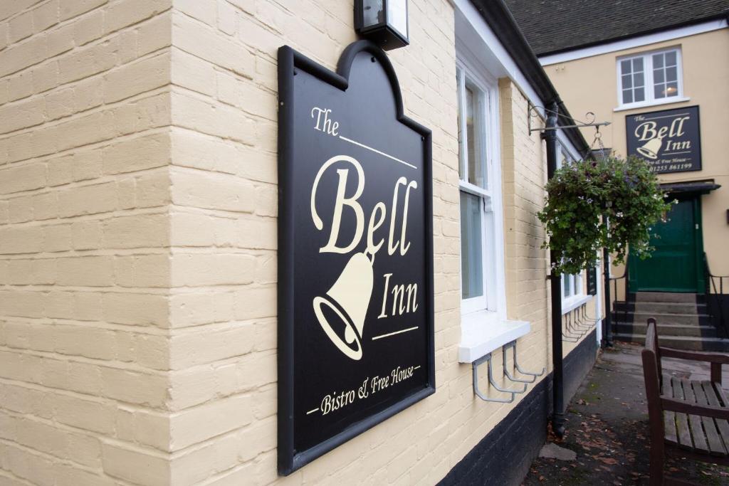 ein Schild für den Gasthof auf der Seite eines Gebäudes in der Unterkunft The Bell Inn in Thorpe le Soken