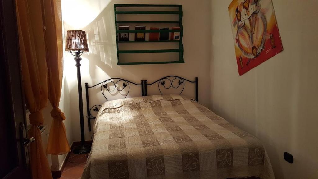 een slaapkamer met een bed met een geruite deken bij Villa Travellito a Martano 13 posti in Martano