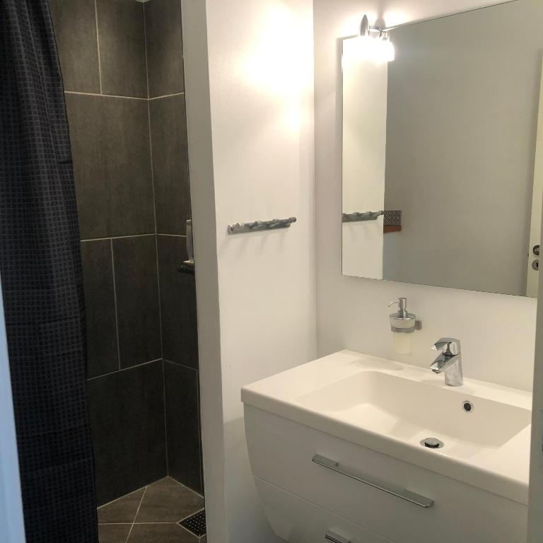 a white bathroom with a sink and a shower at Samsted in Middelfart