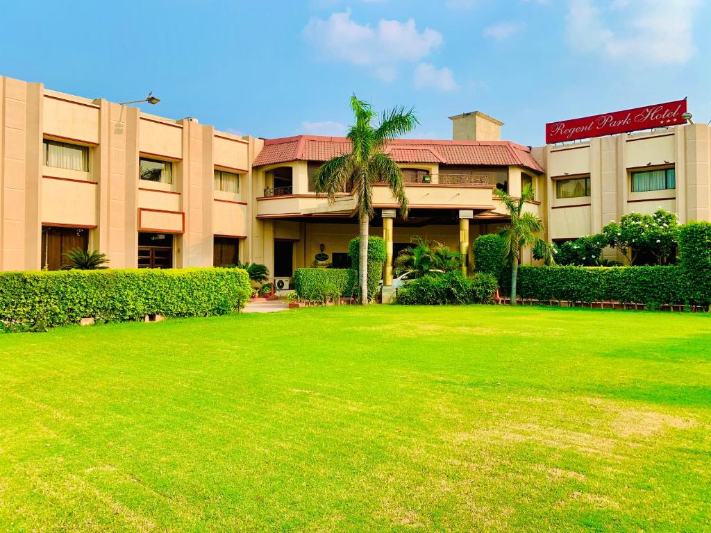 a large building with a lawn in front of it at Regent Park Hotel in Jalandhar