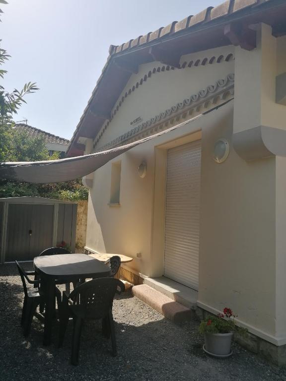 a patio with a table and chairs next to a building at La gravière in Saint-Geours-de-Maremne