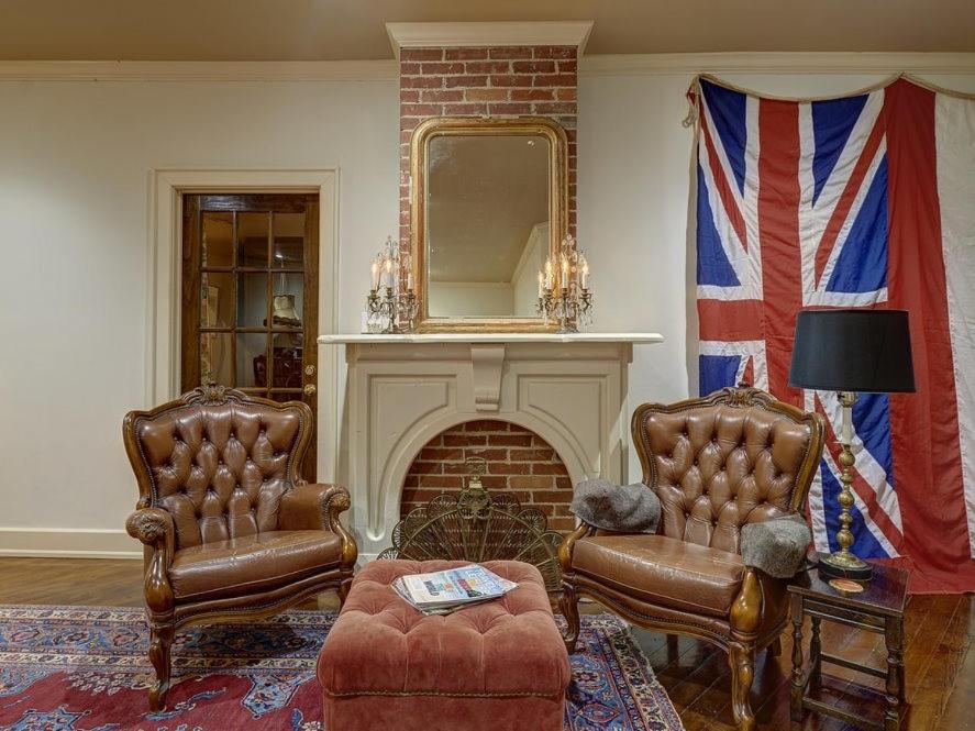 a living room with two chairs and a fireplace at The English Merchant's Inn in Waxahachie