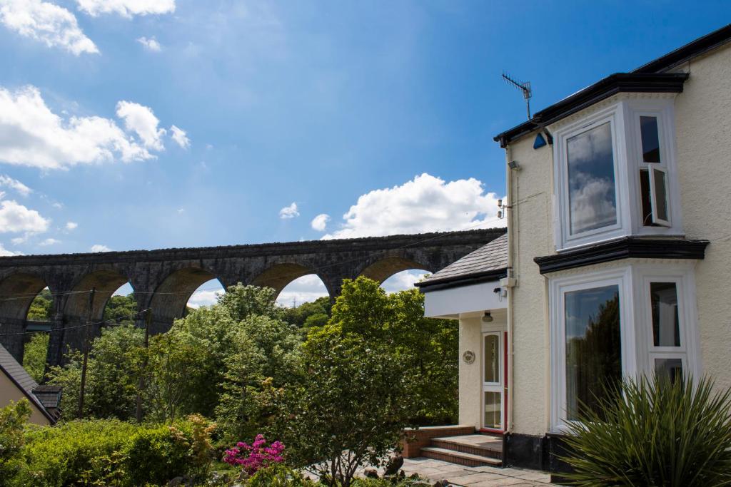a house with a view of a bridge in the background at The Grange Guesthouse, Cefn-Coed in Merthyr Tydfil