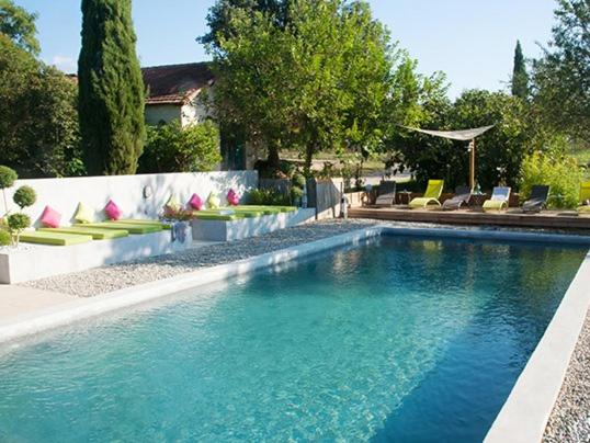 een groot zwembad met stoelen en een huis bij Domaine La Parpaille in Cucuron