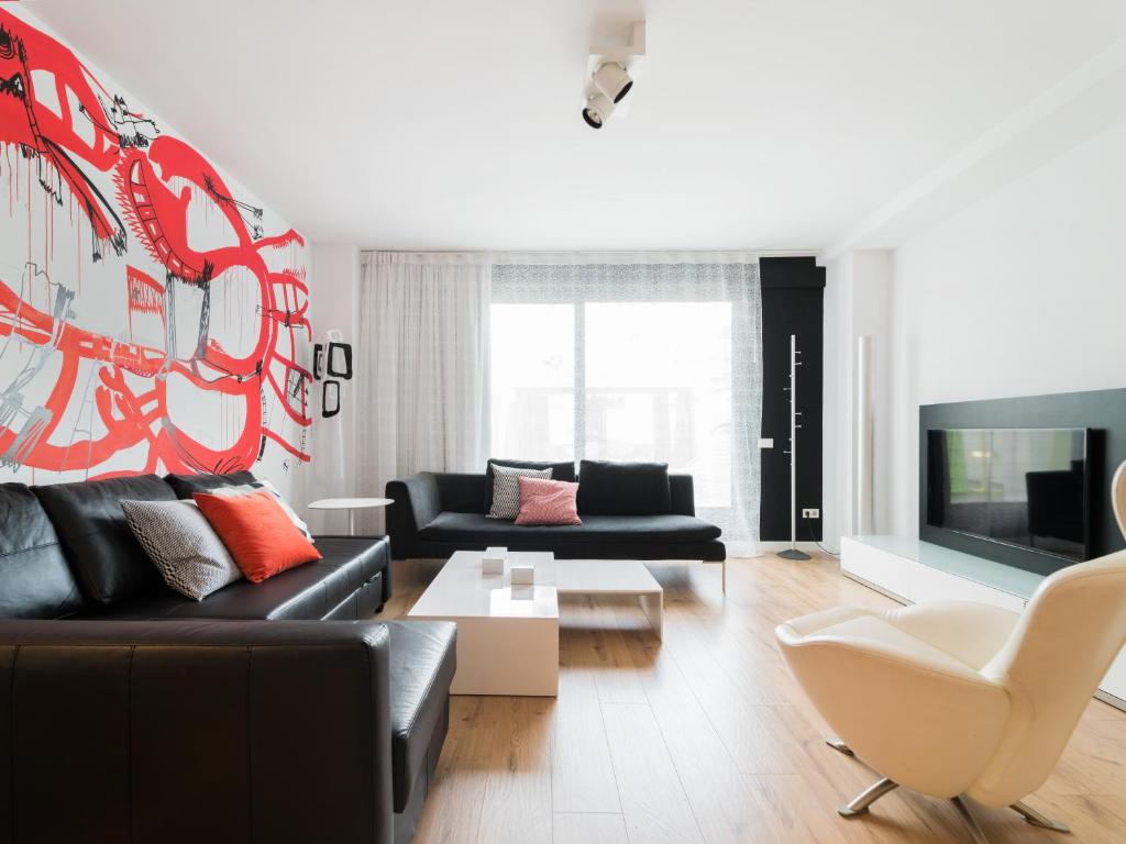 a living room with a couch and a tv at Flat El Porto - families only, no groups in Valencia