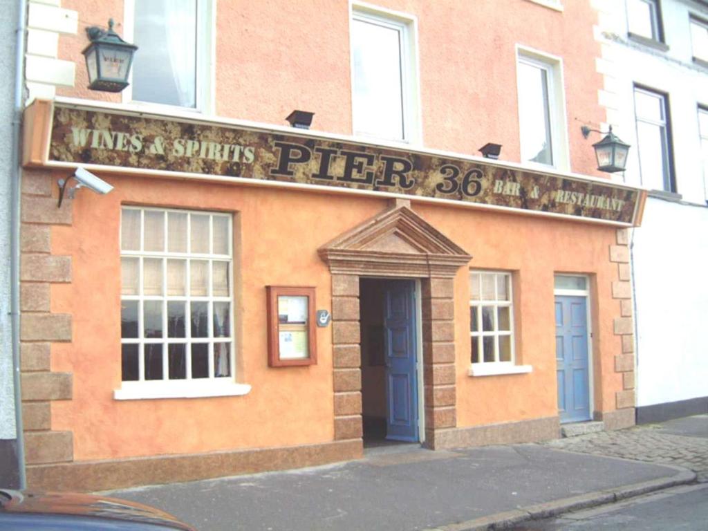 a building with a sign that reads pies and spuds pizza at Pier 36 in Donaghadee