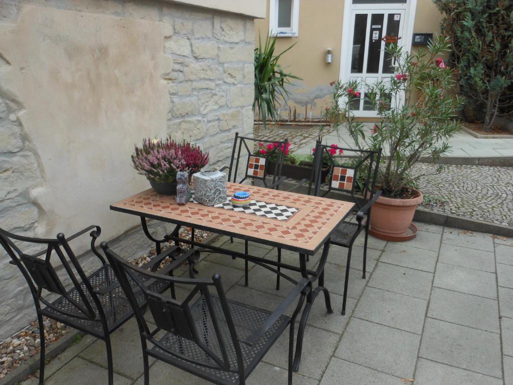 einen Tisch und Stühle auf einer Terrasse in der Unterkunft Pension Am Werder in Bernburg