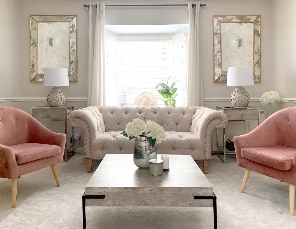 sala de estar con sillas rosas y mesa en Price & Weeks - Heart of Bath, en Bath