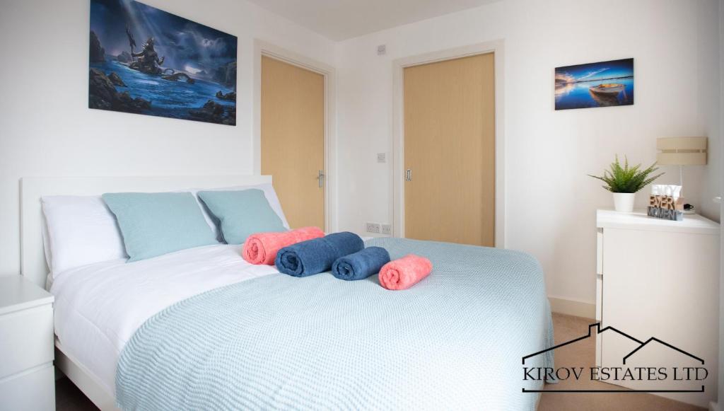 a white bed with blue and pink pillows on it at Poseidon Apartment - 1 Bed Flat - Heart of Town in Southampton