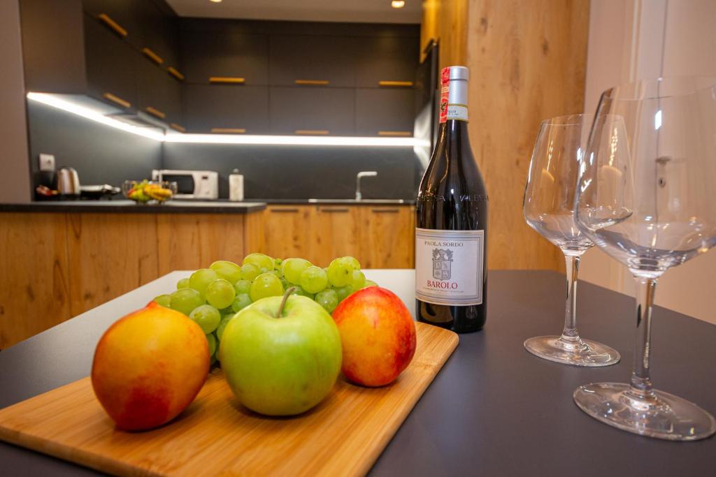 eine Flasche Wein und eine Tafel mit Äpfeln und Trauben in der Unterkunft Central Chic Apartments in Tirana