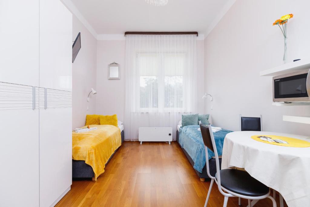 a room with a bed and a table with chairs at Studio Krowoderska Kraków by Renters in Krakow