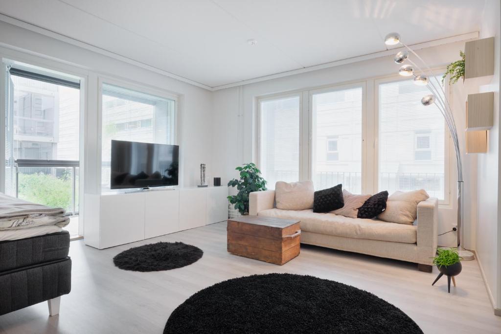 sala de estar con sofá y TV de pantalla plana en Stylish Studio In Pasila, en Helsinki