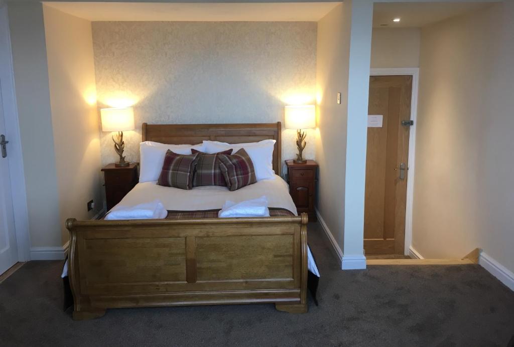 a bedroom with a bed with pillows and two lamps at The Millcroft in Gairloch