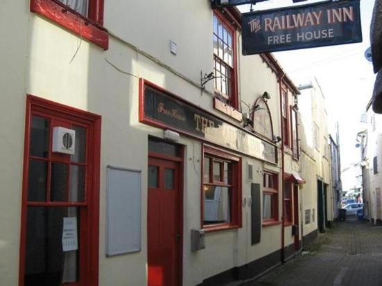 un edificio con un cartel para una casa gratis en The Railway Inn, en Dawlish