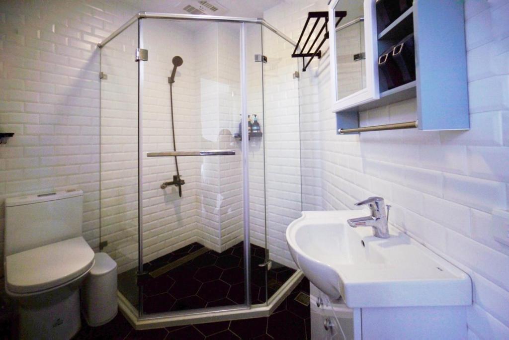 a bathroom with a shower and a sink and a toilet at 東莒 找茶複合式民宿-連江縣民宿199號 in Juguang