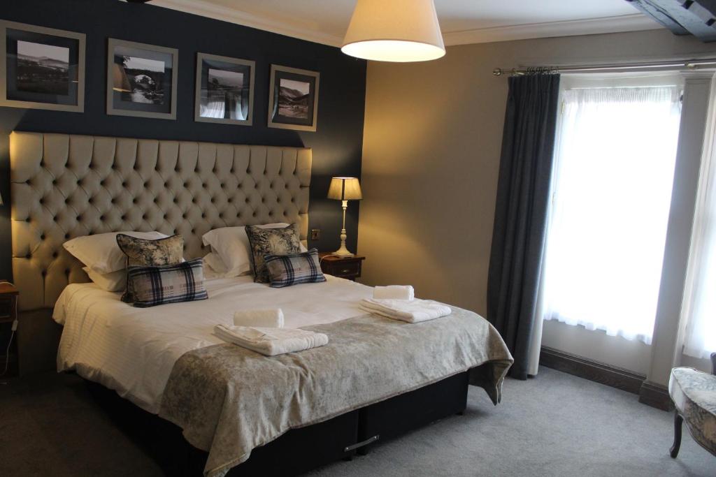 a bedroom with a large bed with a large window at Red Dragon Inn in Kirkby Lonsdale
