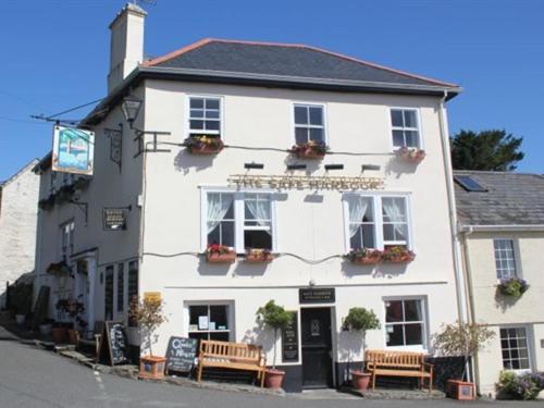 a white building with benches in front of it at The Safe Harbour Hotel in Fowey