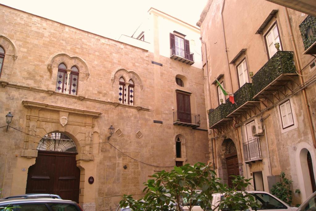 un vecchio edificio in mattoni con cancello e porta di BeeClaire Guest House a Palermo