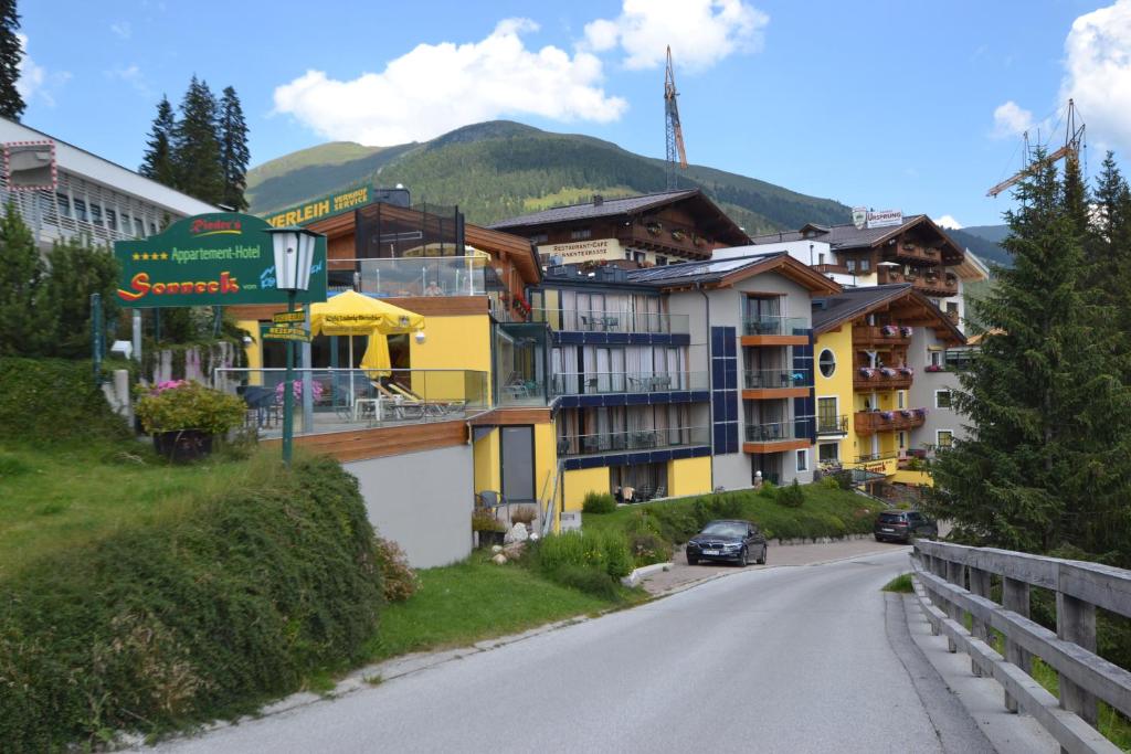 een kronkelende weg in een bergdorp met gebouwen bij Appartement Hotel Sonneck in Königsleiten