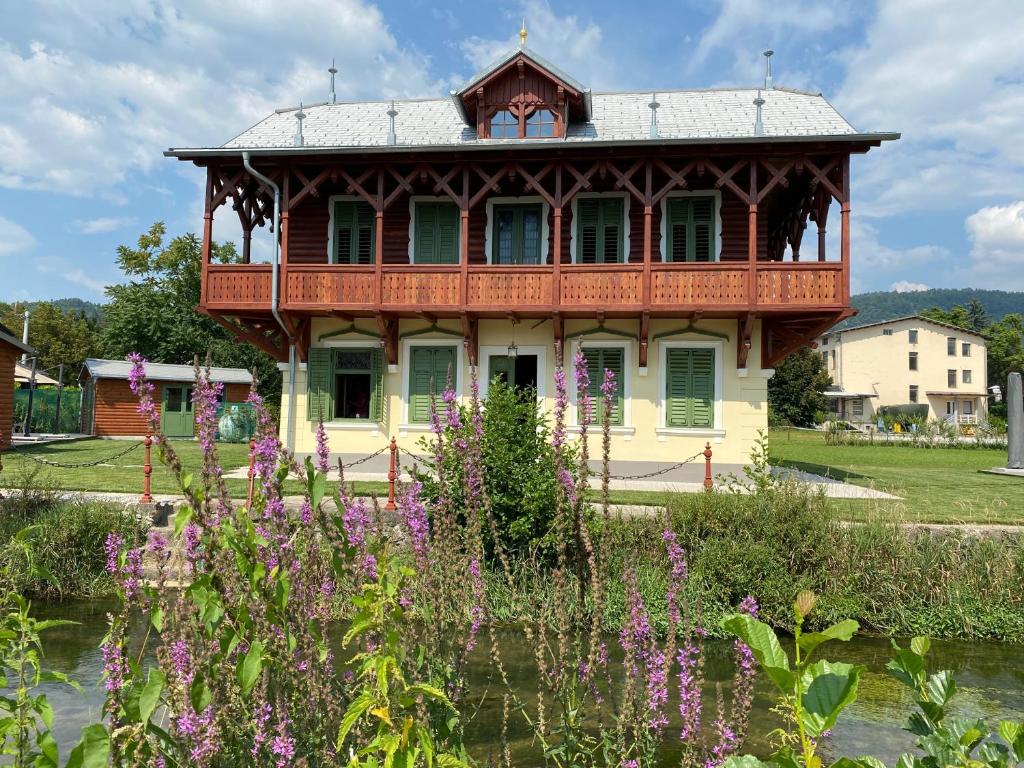 Casa con balcón en un jardín con flores púrpuras en Villa Ruska dača en Liubliana