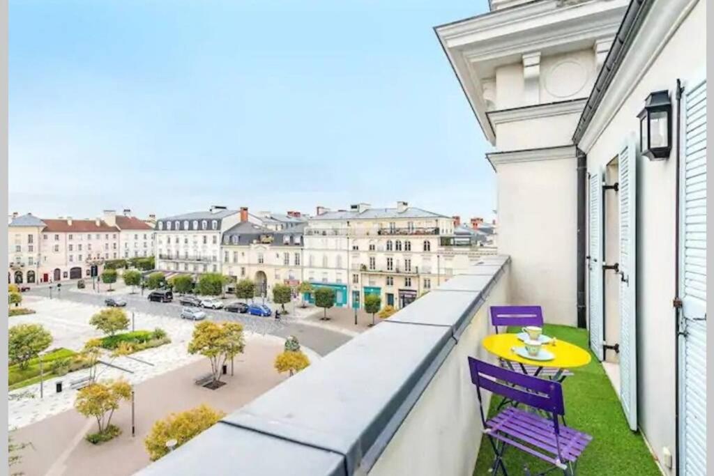balkon ze stołem, krzesłami i ulicą w obiekcie VERY CENTRAL DISNEYLAND apartment w mieście Serris