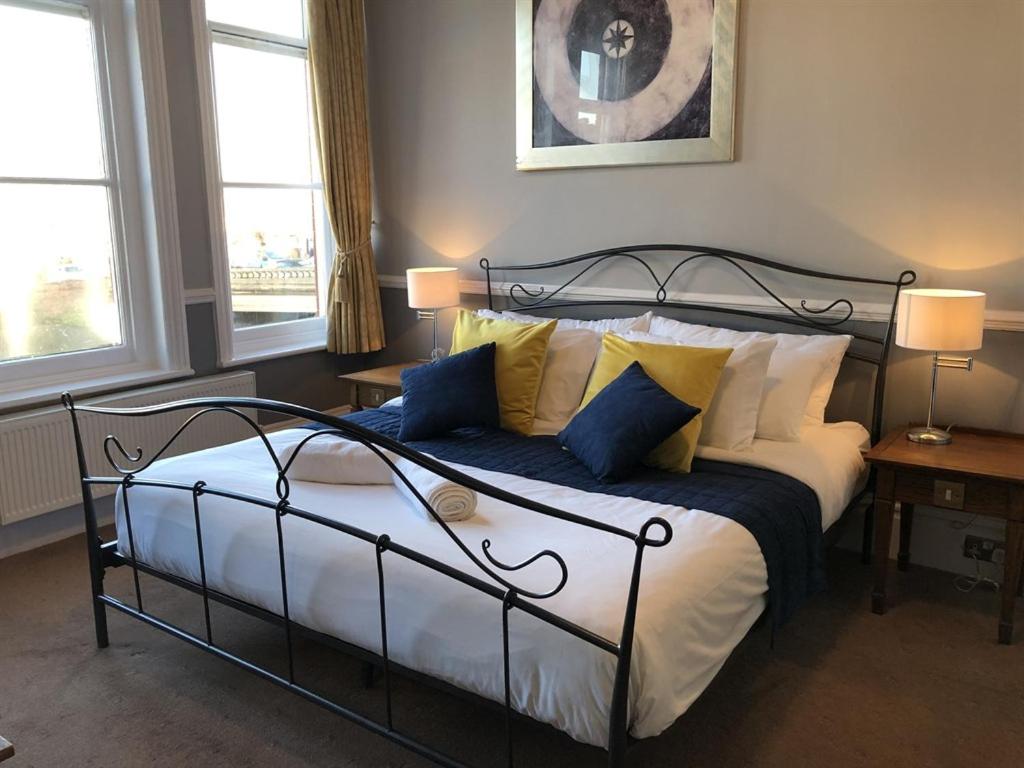 een slaapkamer met een bed met blauwe en witte kussens bij The White Lion Hotel in Wisbech