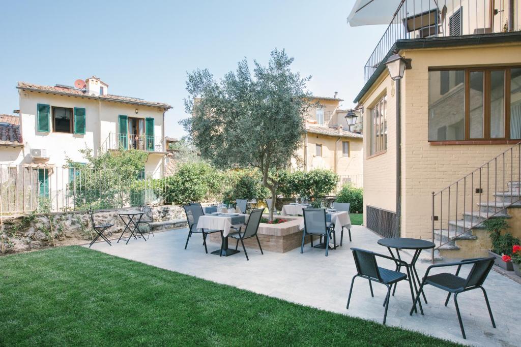 a patio with chairs and tables in a yard at B&B il Barbero in Siena