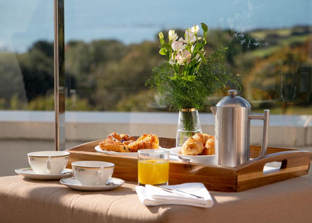 a table with a tray of pastries and coffee and juice at Thurlestone Hotel in Thurlestone