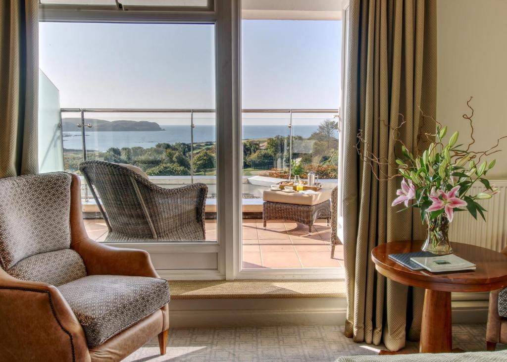 a living room with a large window with a view of a patio at Thurlestone Hotel in Thurlestone
