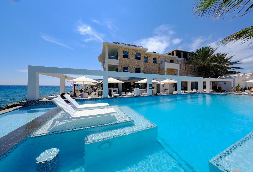 a swimming pool in front of a hotel at Saint Tropez Boutique Hotel in Willemstad