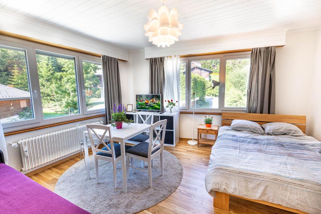 a bedroom with a bed and a table and chairs at Le Clavan - Studio à Crans-Montana (2-4 personnes) in Crans-Montana
