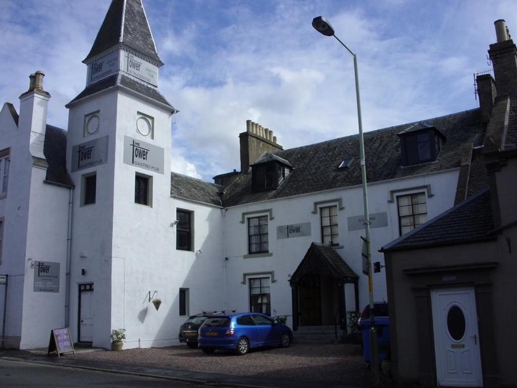 a building with a clock tower and a car parked in front at The Tower Gastro Pub & Apartments in Crieff