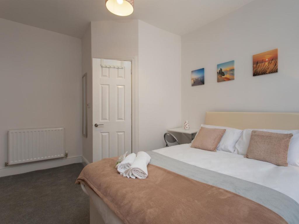 a bedroom with a large white bed and a door at Townhouse PLUS @ Westminster Street Crewe in Crewe