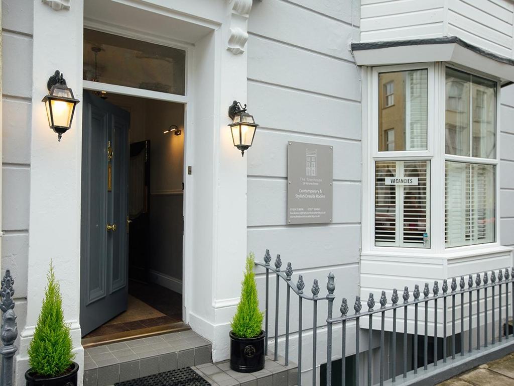 a front door of a white house with two potted plants at The Townhouse in Tenby