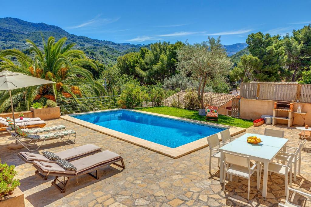 um quintal com uma piscina, uma mesa e cadeiras em Casa Caterina em Port de Sóller