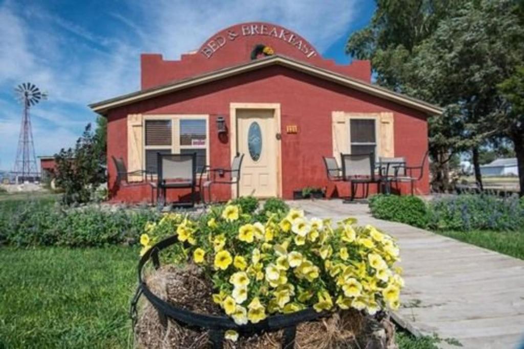 Trail City Bed & Breakfast في Coolidge: منزل أمامه سلة من الزهور