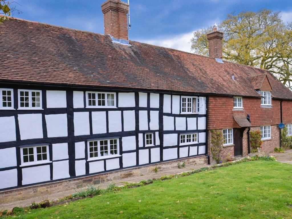 an old black and white building with a grass yard at Twyford Farm B&B in Haywards Heath