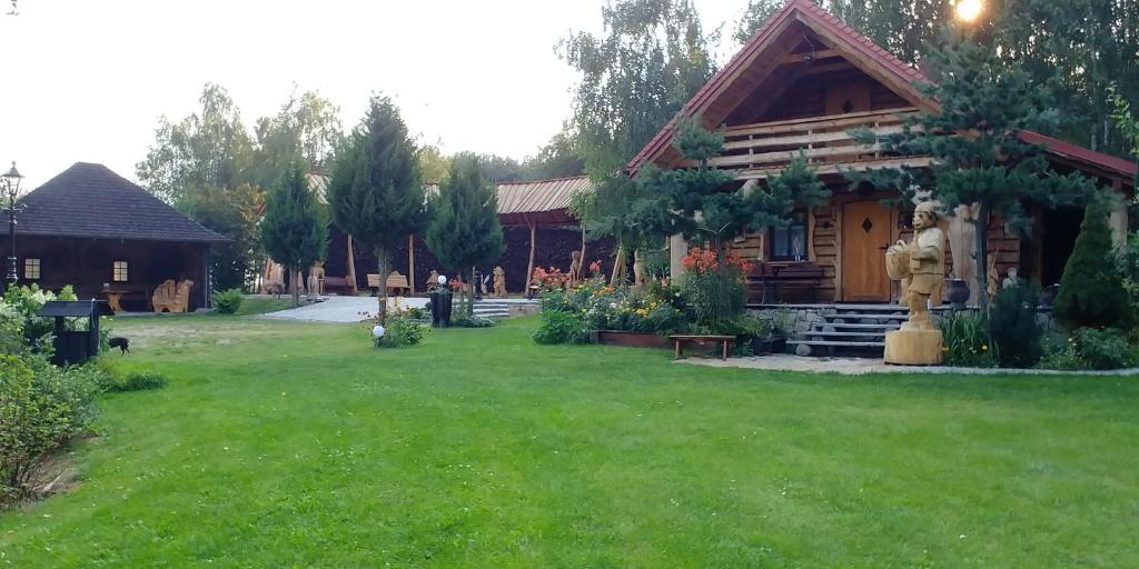 een huis met een groene tuin ervoor bij Stary Spichlerz nad Wartą in Osjaków