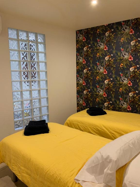 two beds in a room with a blue wall at Hostal Casa Michaels in Móra d'Ebre