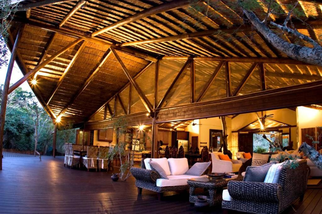 a living room with couches and chairs in a building at Ihlozi Bush Lodge in Hluhluwe