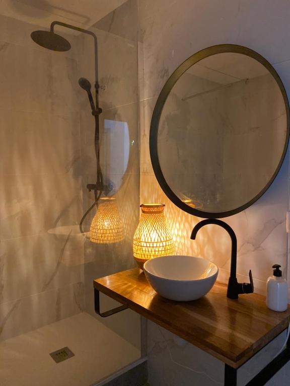 a bathroom with a mirror and a bowl on a table at Shanti Rooms in Valencia