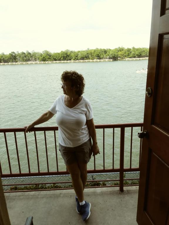 a woman walking on a porch next to a body of water at Bimini Motel in Hollywood