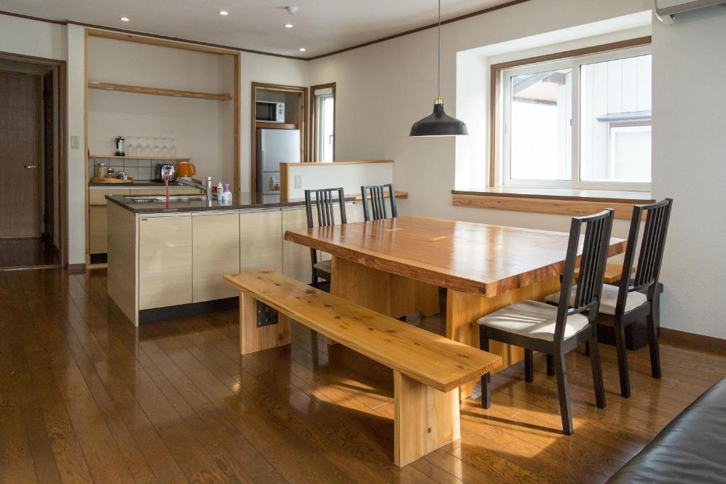 a kitchen and dining room with a wooden table and chairs at Akari House Swiss Bakery in Nozawa Onsen